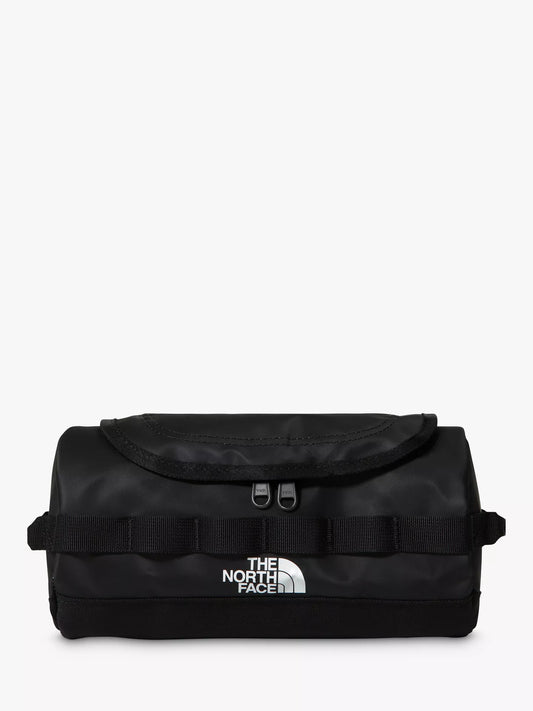 The North Face black canvas tub bag with a front flap, webbing straps, and a white logo on the front, set against a plain white background.