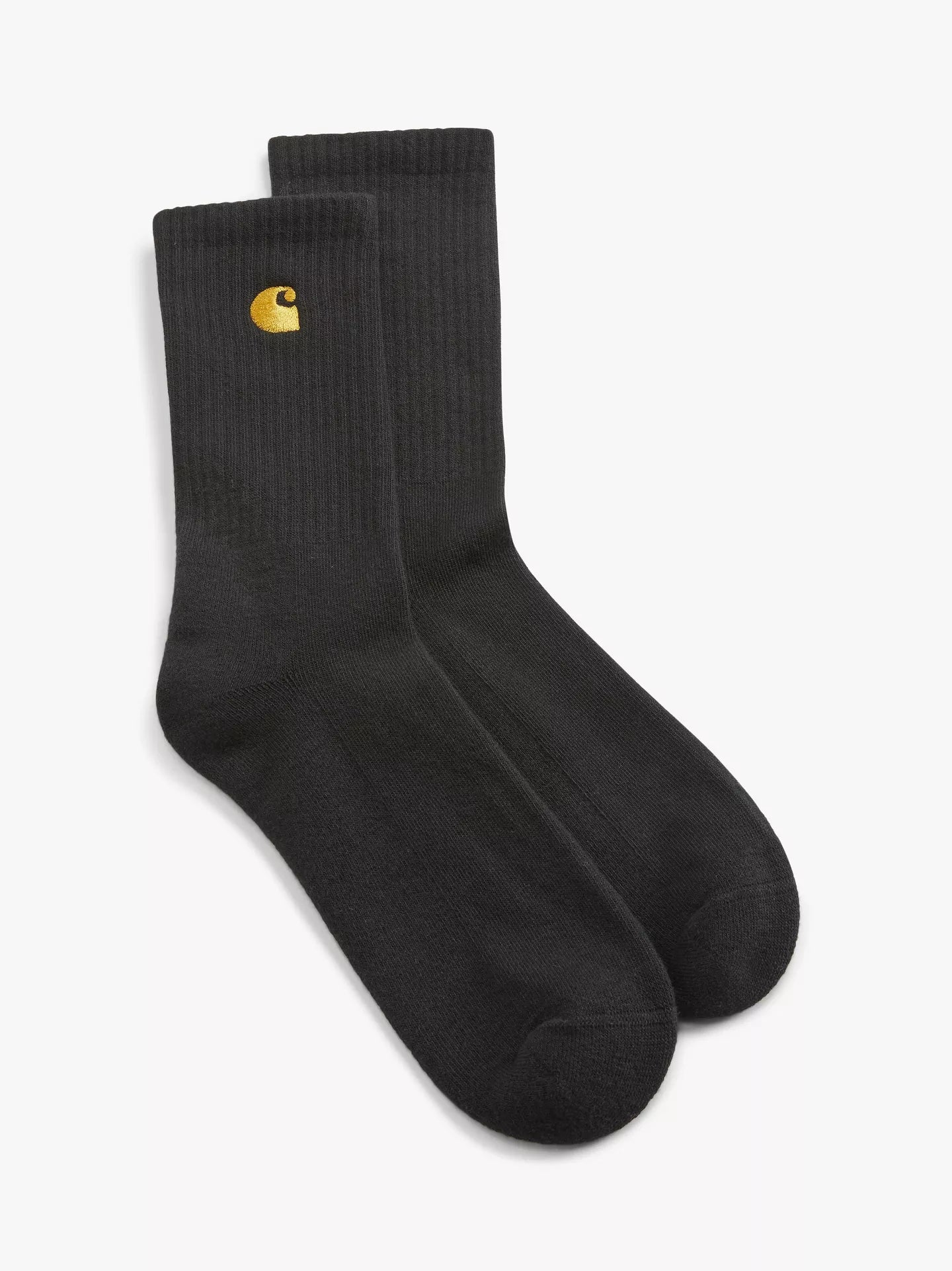 A pair of black crew socks with a small yellow Carhartt logo on the cuff, displayed against a clean white background.