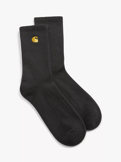 A pair of black crew socks with a small yellow Carhartt logo on the cuff, displayed against a clean white background.