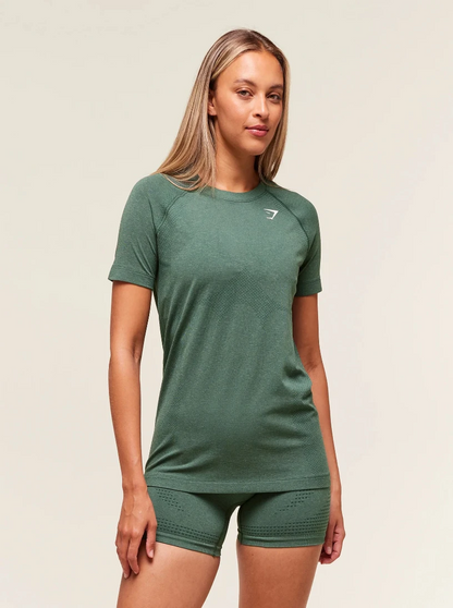 Woman wearing a green athletic outfit with a logo on a beige background