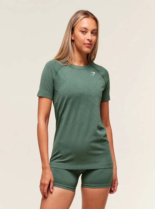 Woman wearing a green athletic outfit with a logo on a beige background