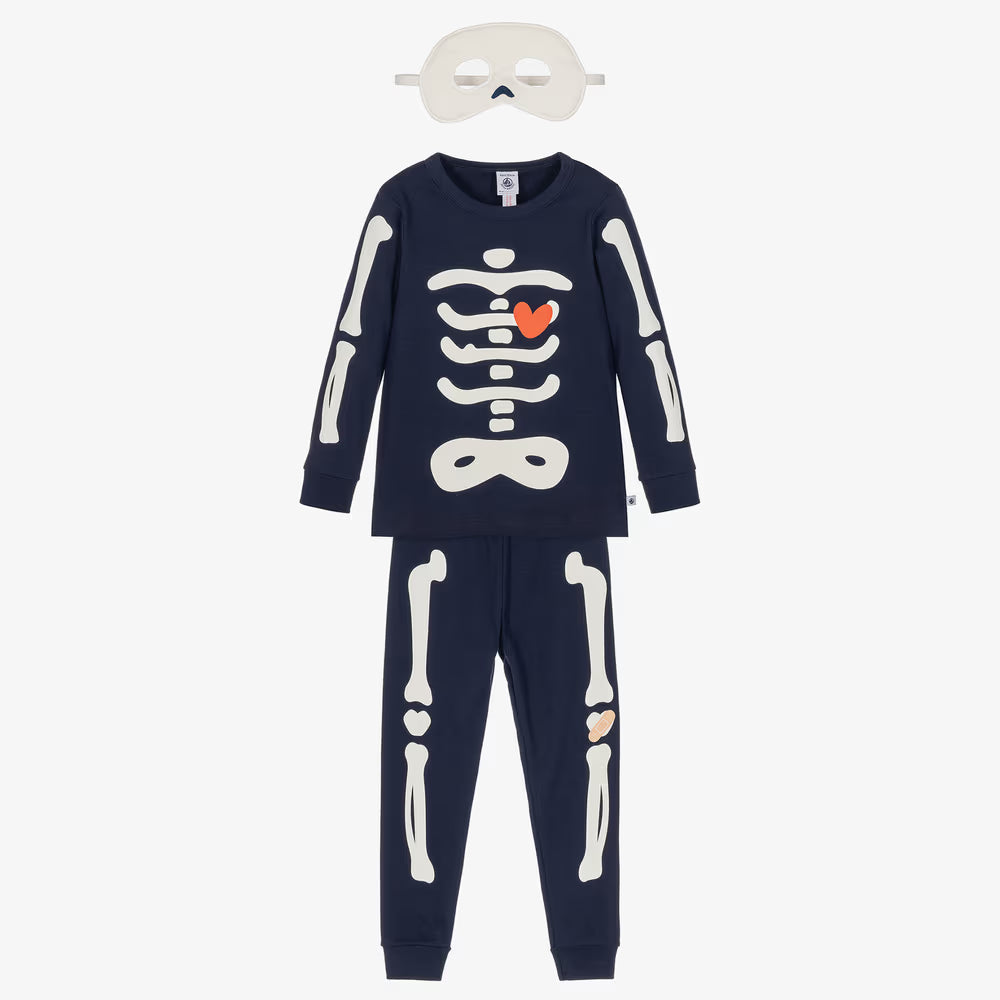 A children's two-piece skeleton-themed pajama set in navy blue, featuring a long-sleeve top and matching pants with white bone graphics. The top has a white rib cage graphic with a small orange heart in the center.