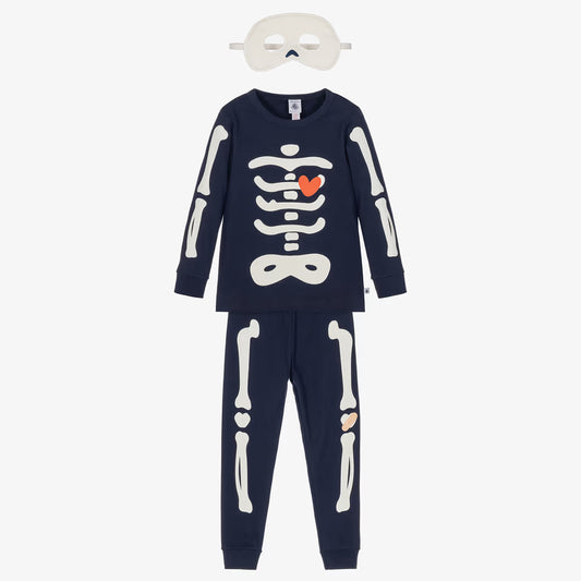 A children's two-piece skeleton-themed pajama set in navy blue, featuring a long-sleeve top and matching pants with white bone graphics. The top has a white rib cage graphic with a small orange heart in the center.