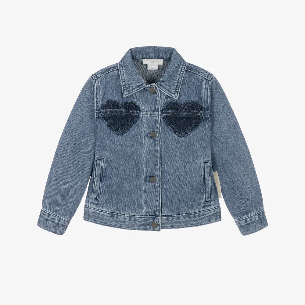 A light blue denim jacket for kids, featuring two dark blue heart-shaped patch pockets on the chest, a button-up front, and a classic collar, shown against a plain white background.